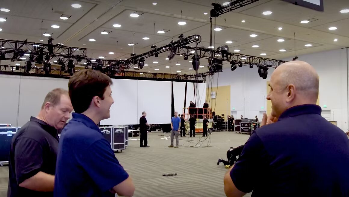 FiveEleven team during load-in: production conversation under hung truss and lighting