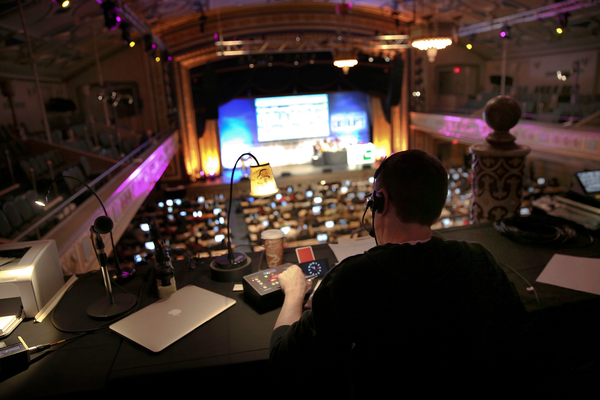 FiveEleven show-caller at front-of-house in a historic theater, headset on, calling cues