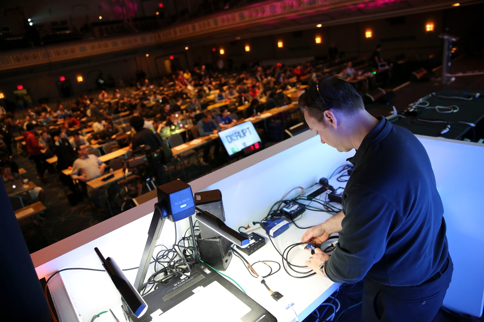 FiveEleven engineer at the tech table managing presentation playback for a packed ballroom